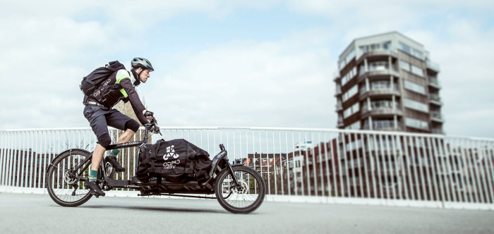 fietskoerier rijdt snel door de stad